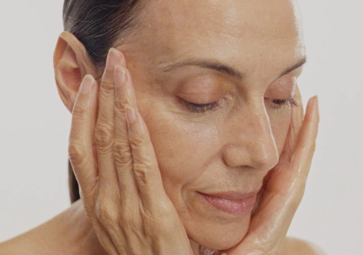 Woman touching her face with a neutral background